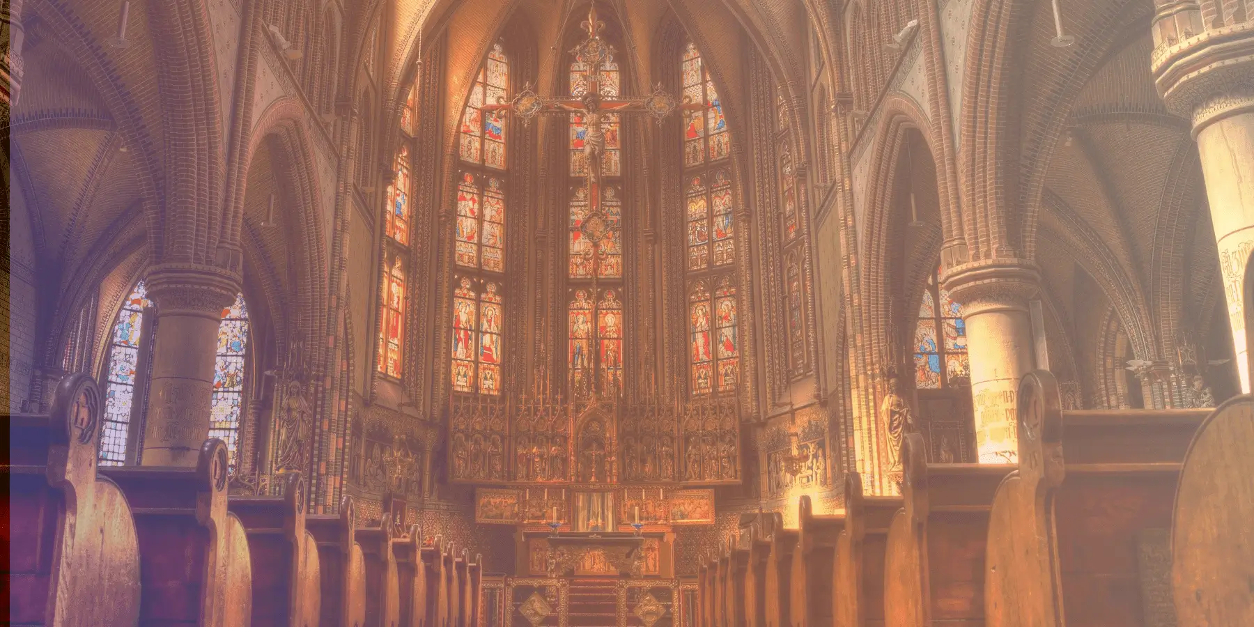 Interior of a grand cathedral with stained glass windows and ornate decorations.